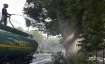 A worker sprays water on trees as part of efforts to curb