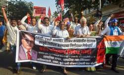 Dalit activists and supporters hold placards and raise