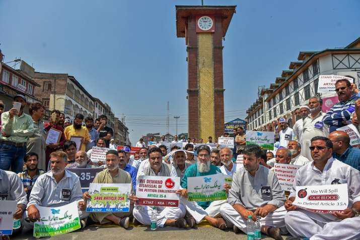 Kashmiri traders hold placards and raise slogans