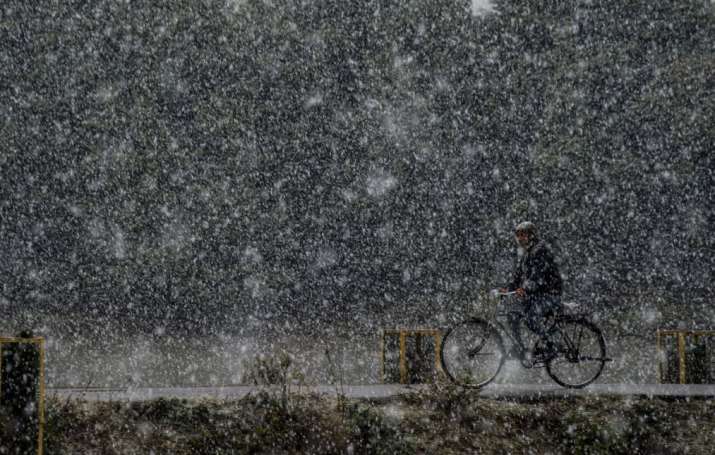 Srinagar: A man rides a bicycle during season's first